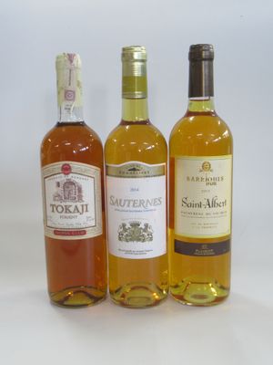 three bottles of wine sitting next to each other on a white surface