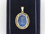 un gros plan sur une pierre bleue sertie dans un pendentif plaqué or