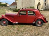 a red car that is parked in the grass