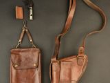 two leather holsters hanging on a wall next to each other