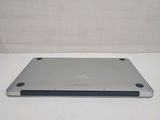the back of a silver laptop computer sitting on top of a white table