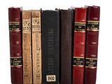 plusieurs vieux livres sont empilés sur une surface blanche
