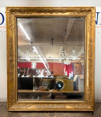 un miroir à cadre doré posé sur une table dans une pièce