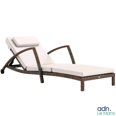 La chaise longue est en osier et est équipée d'un coussin blanc.