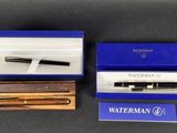 deux stylos à plume dans une boîte bleue et un stylo dans une boîte en bois