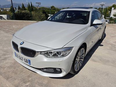 Une berline BMW Série 3 blanche garée dans un parking