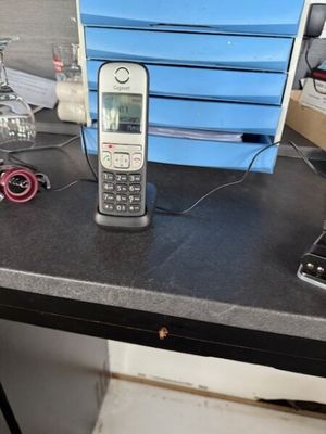 un téléphone portable posé sur un bureau, à côté d'une pile de cartons