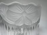 a clear glass vase with a flower design on it