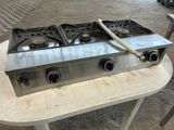 a gas stove that is on top of a table