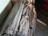un tas de bois posé dans un garage, à côté d'un tas d'outils