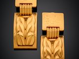 pair of carved wood earrings with flowers and leaves on them