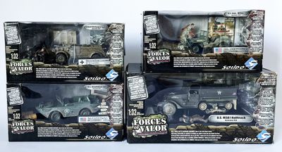 trois jouets représentant des véhicules militaires, présentés dans leurs boîtes, posés sur une surface blanche