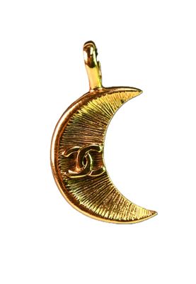 the gold crescent pendant has a chanel logo on it
