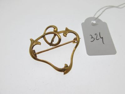 une broche plaquée or ornée d'un cœur et d'une flèche