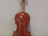 a close up of a violin on a table with a wall in the background