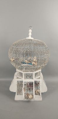 une cage à oiseaux blanche avec un oiseau à l'intérieur