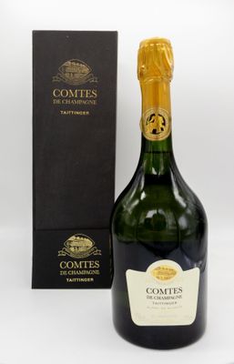 a bottle of champagne with a box of chocolates in the background