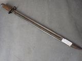an old sword with a wooden handle on a gray surface