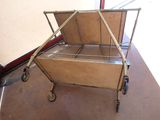 a metal cart with a wooden top on the floor