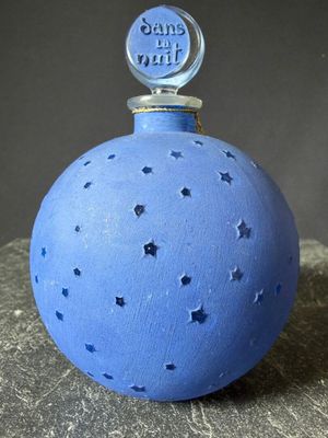 a blue bottle with stars on it sitting on a rock