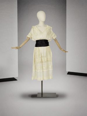 mannequin vêtu d'une robe blanche avec une ceinture noire et une ceinture noire