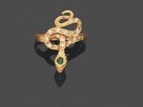 une image représentant une bague en or avec une pierre verte au centre
