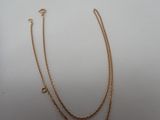 a gold necklace with a chain that has a heart on it