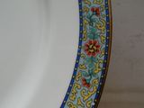 une assiette blanche bordée de bleu et de jaune