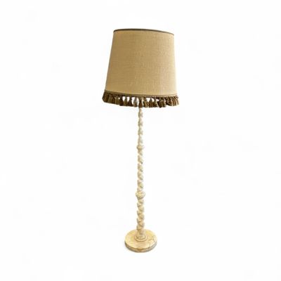 une lampe de table blanche surmontée d'un abat-jour beige