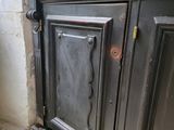 a black cabinet with a black door and a white wall