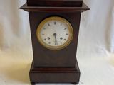 une petite horloge en bois sur fond blanc
