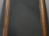 an antique gold framed mirror with a black background