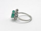 silver ring with a green stone and a silver band on a white surface