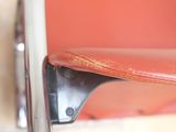 a close up of a red chair with a leather seat