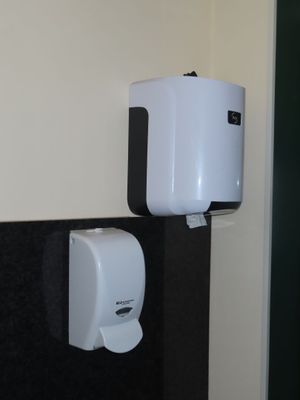 une photo d'une salle de bains en noir et blanc avec un distributeur de papier toilette fixé au mur