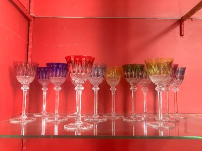 de nombreux verres à vin alignés sur une étagère en verre