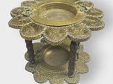 a gold plate with a flower on it on a stand