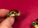 a person holding a piece of jewelry on a red surface