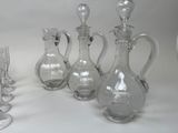 four glass vases and a wine glass on a table