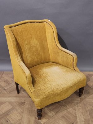 une chaise jaune posée sur un parquet, près d'un mur gris