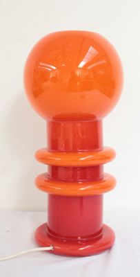 an orange lamp that is on top of a table