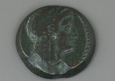 une ancienne pièce de bronze sur laquelle figurent un cheval et un cavalier