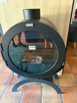 a black stove sitting on a brick floor in a living room