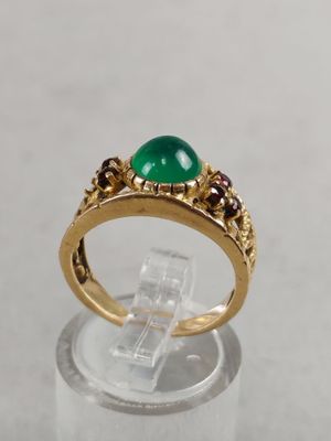 a close up of a gold ring with a green stone on it