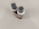 two bottles of liquid sitting on a white surface