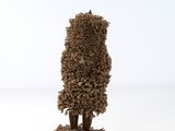 une petite sculpture représentant un arbre, réalisée à partir de petits cailloux