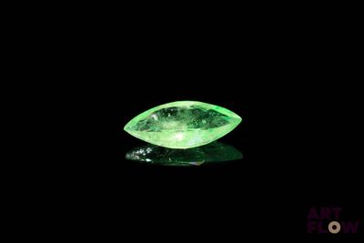 gros plan d'un diamant vert sur une surface noire