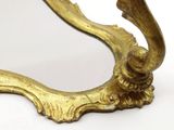 a gold mirror with a bird on it on a white surface