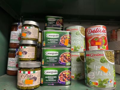 de nombreuses boîtes de conserve posées sur une étagère dans une cuisine