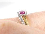 a woman ' s hand holding a pink stone and diamond ring